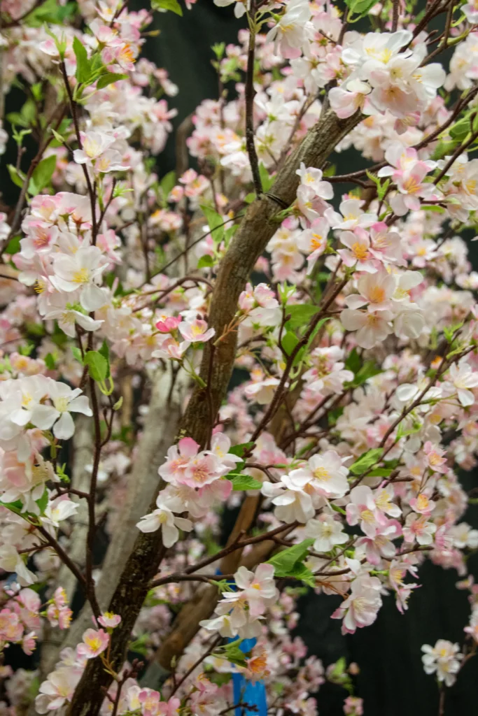 Artificial cherry blossom tree with brown textured branches and clusters of delicate pink and white flowers.