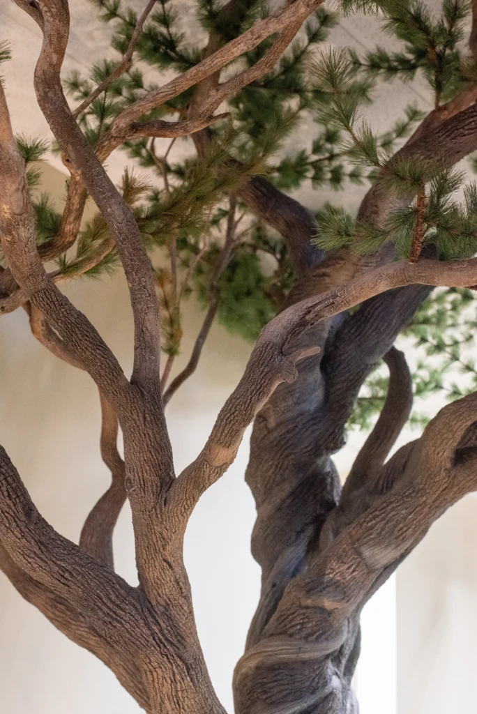 Artificial Ancient Bristlecone Pine tree with twisting branches and green needle foliage extending upward toward the ceiling.