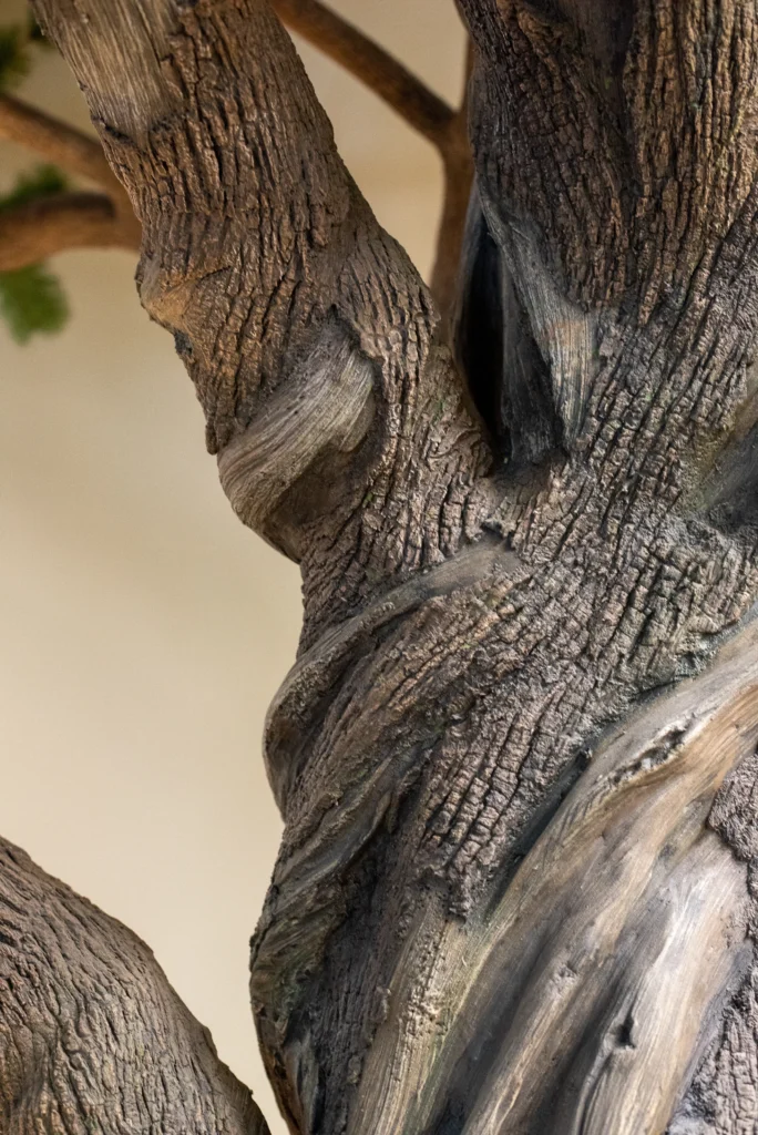 Detailed view of artificial Ancient Bristlecone Pine tree trunk with twisting grooves and textured bark surface.